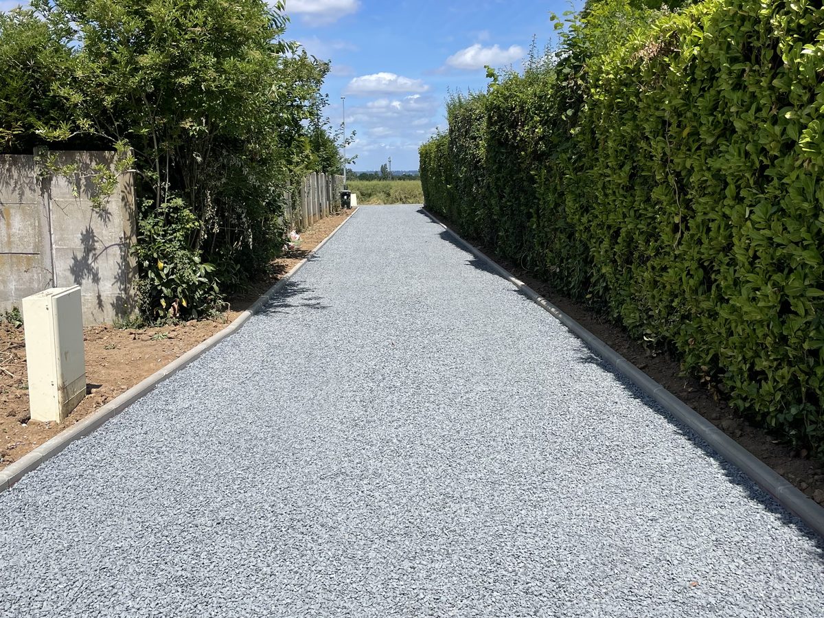 Allée en graviers concassés gris avec bordures béton en Normandie
